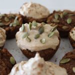 A close up of some cupcakes with frosting and pumpkin seeds